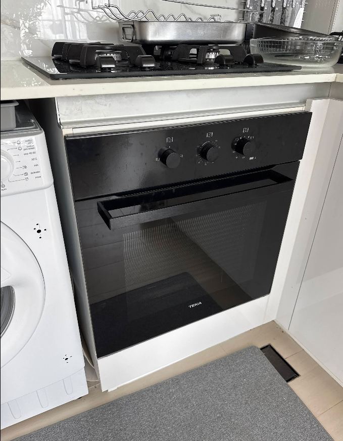 Technician repairing a built-in oven and hob