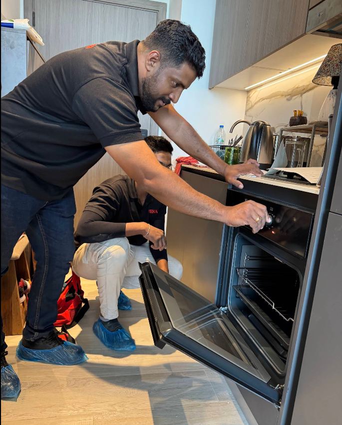 Technician repairing a built-in oven in a Dubai kitchen