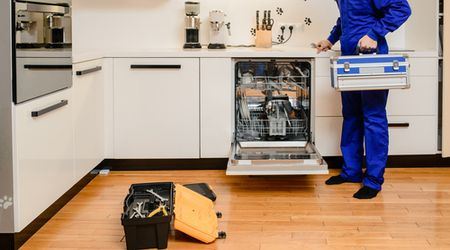 Open dishwasher with technician tool case in a kitchen